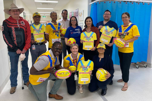 Tami Photinos and Melanie Dubbelde with staff of Adult Intensive Care Service wearing bright yellow jerseys on Jersey Day at TPCH 