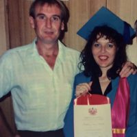 Kathie Powter with husband at graduation holding Bachelor of Education certificate