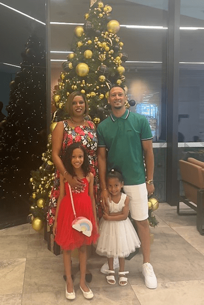 Kirsch and Kersha Jacobs with family pictured in front of a large Christmas tree