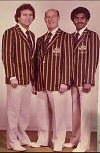 Gourp photo of Norm Stevens in group photo, with two others, wearing Olympic uniform