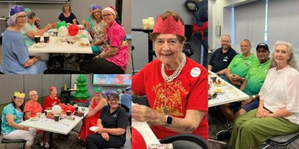 Groups of Caboolture Hospital volunteers celebrating Christmas seated at table 