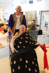 Gannet House resident Elsje cutting the ribbon that opened the new entertainment area