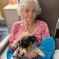 Recent patient Marlene enjoying a dog cuddle