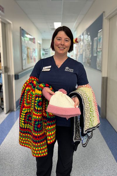 Samantha a renal nurse at RBWH hold her knitted pieces for patients