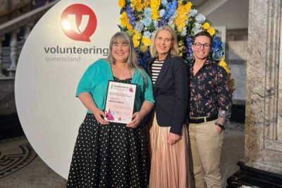 The Common Good’s Volunteer Coordinator holding award beside Bretine Curtis and Parker Michaels 