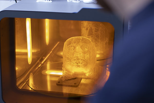A transparent orthosis being UV cured after SLA printing.