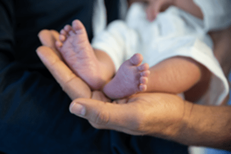Baby feet held by a hand
