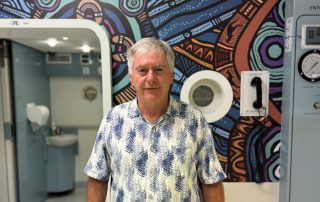 Bob Campbell stands in front of the RBWH hyperbaric chamber
