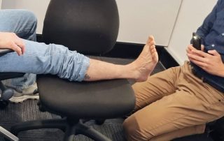 Patient foot resting on chair while being photographed by mobile phone