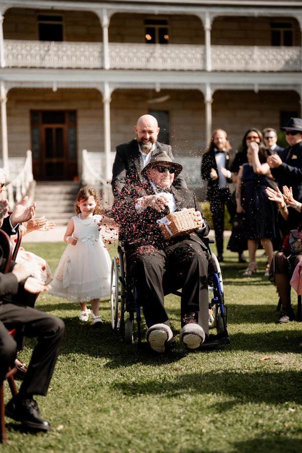 Roy taking on 'flower girl' duties at his grand daughter's wedding thanks to his customised wheelchair seating.
