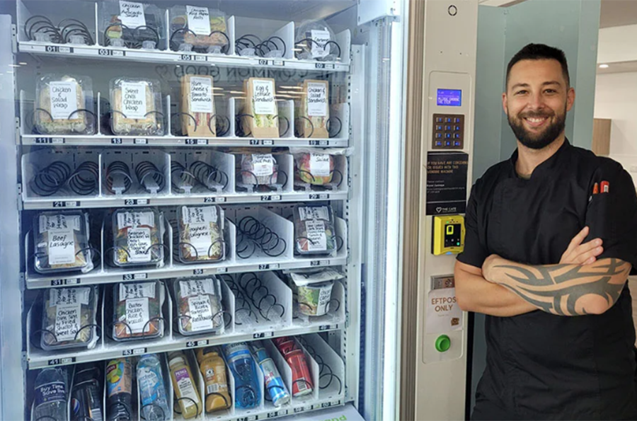 Man standing next to food vending machine