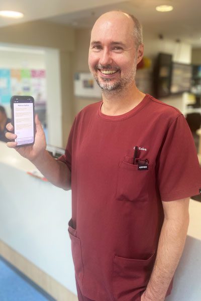 The Prince Charles Hospital Geriatrician Dr Eamonn Eeles holding mobile phone