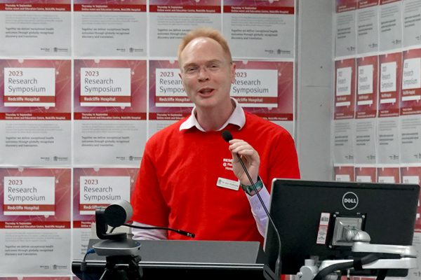 Dr Joel Dulhunty at the podium welcoming guests to the 2023 Redcliffe Hospital Research Symposium