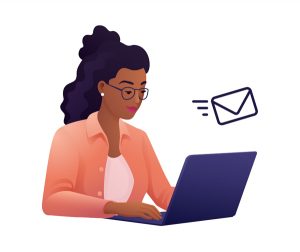 A lady smiling and sending an email on a laptop