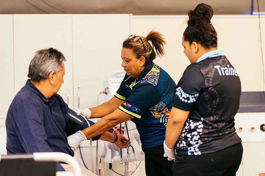 Aboriginal and Torres Strait Islander staff taking a patients blood pressure.