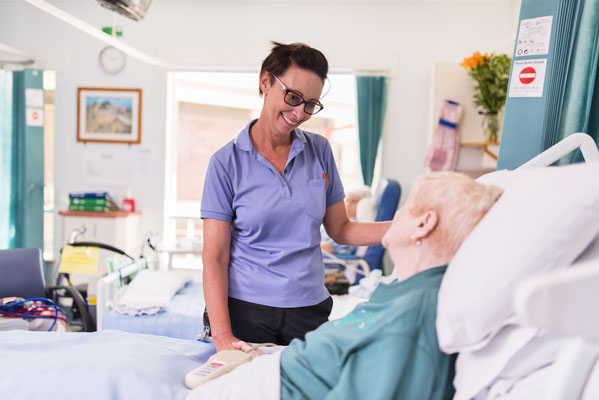 Nurse speaking with elderly female patient
