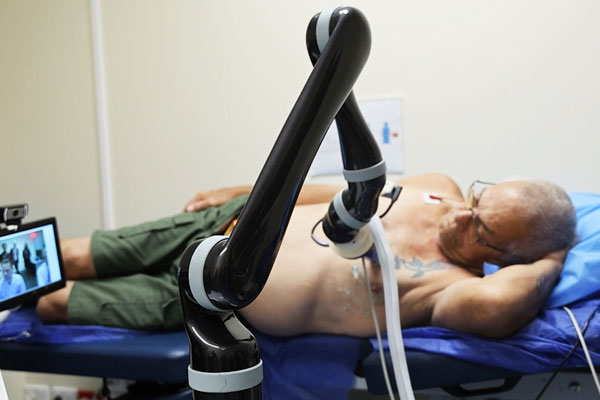 Patient receiving echocardiogram from robotic arm technology