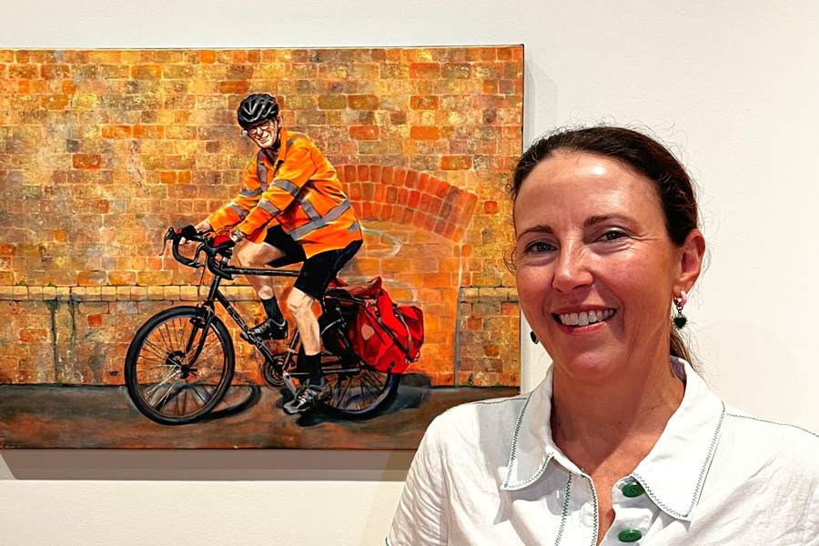 Jane with her artwork of Dr Jeremy Hayllar, hanging in the State Library of Queensland.